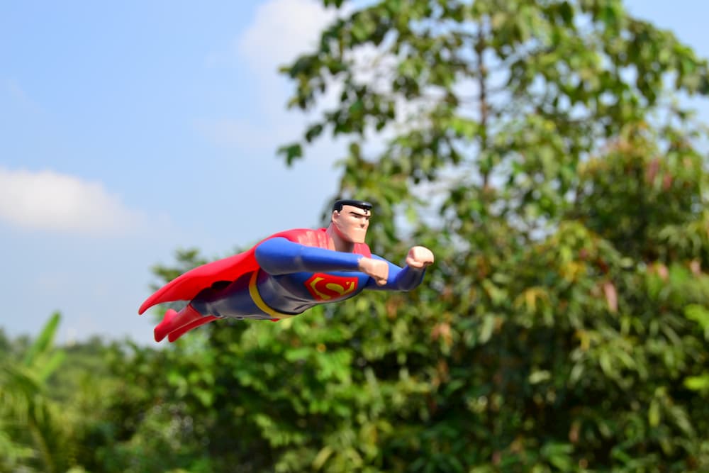 Superman doll appearing to fly through the air.