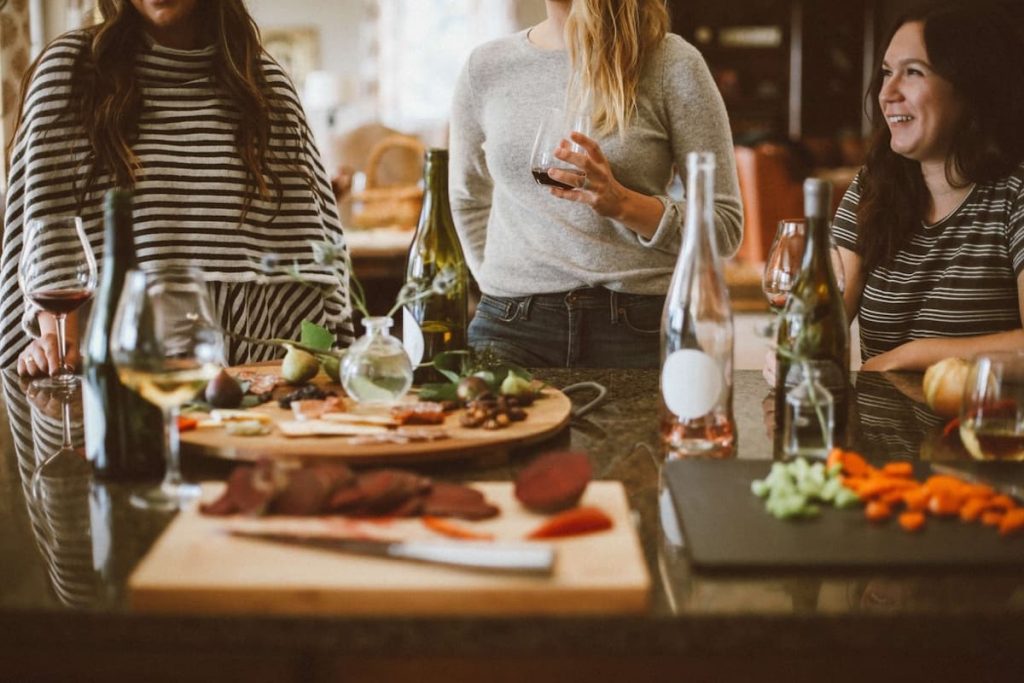 Photo of friends chatting and drinking wine by Kelsey Chance on Unsplash